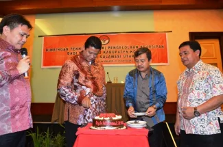 Ketua Bawaslu RI, Muhammad memotong kue ucapan selamat atas diraihnya gelar Profesor.