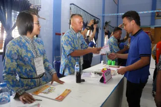 Petugas KPPS TPS Khusus 11 Lapas Sumompo, Tuminting Kota Manado menyerahkan surat suara kepada salah satu pemilih Pilkada Kota Manado 2016, Rabu (17/2).