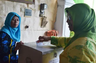 Pimpinan Bawaslu Endang Wihdatiningtyas memasukkan surat suara ke kotak suara.