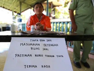 Pemberitahuan dari KPPS terkait tata cara untuk mencelupkan jari ke tinta, dalam Pemilu Presiden dan Wakil Presiden Tahun 2014, di Sulawesi Utara, (9/7).